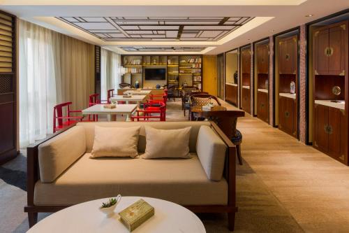 a living room with a couch and tables and chairs at LN Hotel Five in Guangzhou