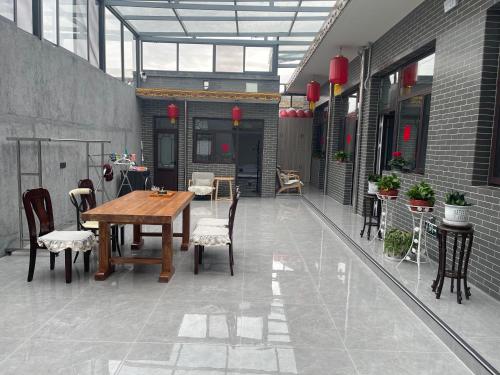 an outdoor patio with a wooden table and chairs at 少东家公馆二号院 in Pingyao