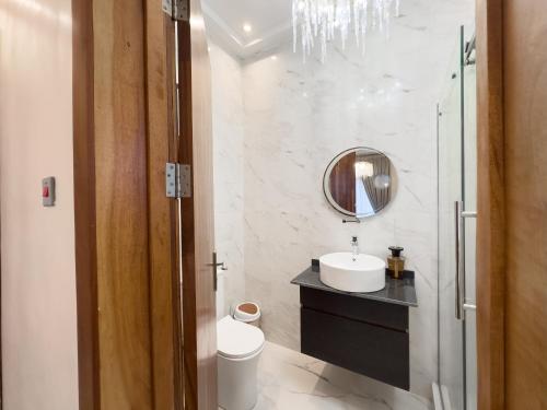 a bathroom with a sink and a mirror at Teflon suites Kumasi in Kumasi