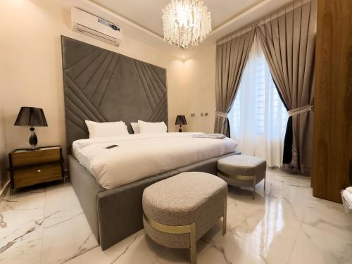 a bedroom with a large bed and a chandelier at Teflon suites Kumasi in Kumasi