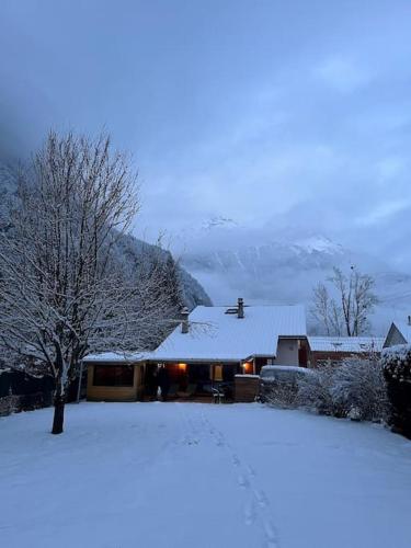 une maison recouverte de neige avec un arbre dans l'établissement Chalet Galibert, SKI - CYCLE - HIKE in the Oisans, à Grandes Sables