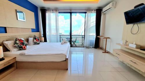 a bedroom with a bed and a large window at Samed Port View in Ko Samed