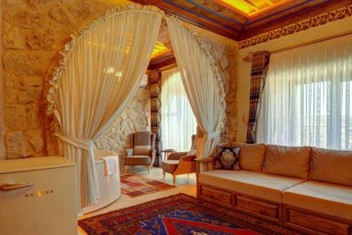 a living room with a couch and a window at Kasr-ı Kapadokya Cave Suites in Ortahisar