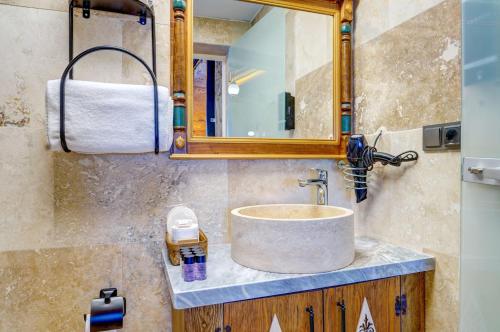 a bathroom with a sink and a mirror at Kasr-ı Kapadokya Cave Suites in Ortahisar