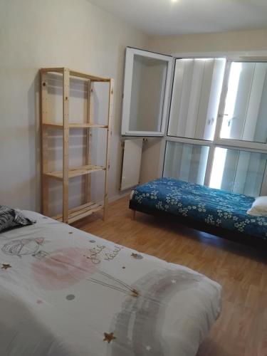 Cette chambre comprend 2 lits et quelques étagères. dans l'établissement Appartement bien situé, à Rennes