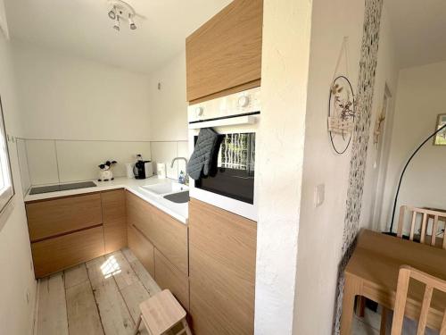 une cuisine avec un évier et une cuisinière four supérieur dans l'établissement Olbius Magnifique studio climatisé, à Hyères