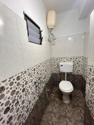 a bathroom with a toilet and a tub with a window at Geranium Homestay in Darjeeling