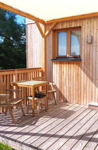 a wooden deck with a table and chairs on it at Tiny Haus "Mrs Green" - Boutique Loft Nina&Susanne in Drosendorf Stadt