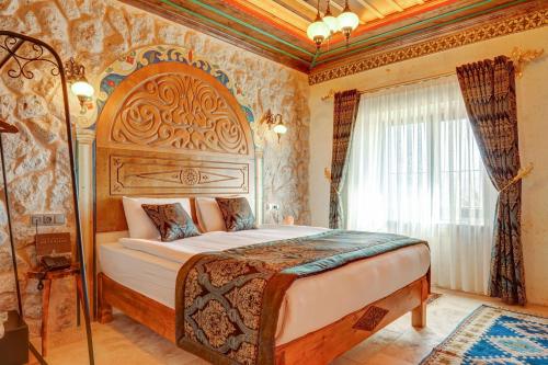 a bedroom with a large bed in a room at Kasr-ı Kapadokya Cave Suites in Ortahisar