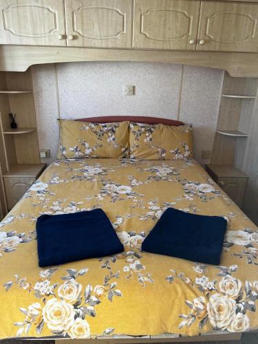 a bed with two blue bags on top of it at 2 Bedroom caravan Hunstanton pets go free in Hunstanton