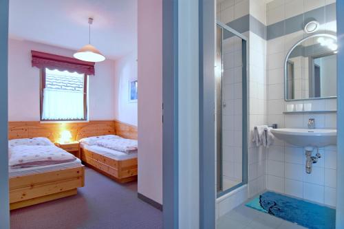 a bathroom with two beds and a sink and a shower at Haus Bergblick in Faak am See