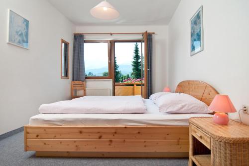 a bedroom with a wooden bed and a window at Haus Bergblick in Faak am See