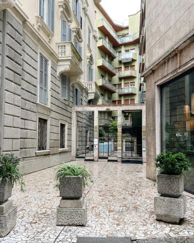 a courtyard with potted plants in front of a building at Alatea Porta Nuova 20 in Verona