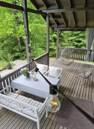 eine Veranda mit Schaukel, Tisch und Stühlen in der Unterkunft Miiluranta Villas in Haapamäki
