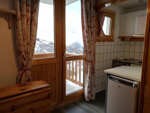 Il comprend une cuisine avec une fenêtre offrant une vue sur la montagne. dans l'établissement Studio cosy à Plagne Villages, balcon ouest, centre station, proche pistes et commerces, 4 pers. - FR-1-351-71, à La Plagne