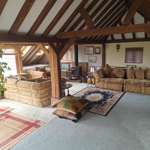 a large living room with couches and a fireplace at Hale Oaks Farm in Rudgwick