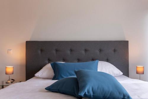 a bedroom with a large bed with blue pillows at Ferienhaus Annabelle in Crivitz