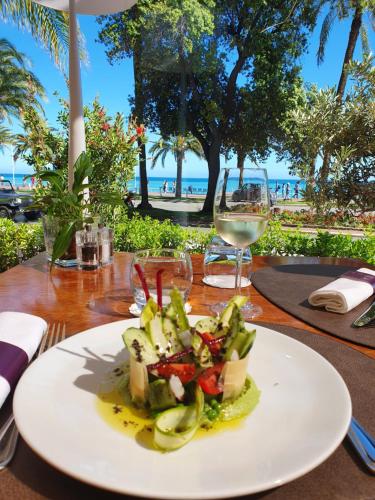 a plate of food on a table with a view of the beach at Westminster Hotel & Spa Nice in Nice