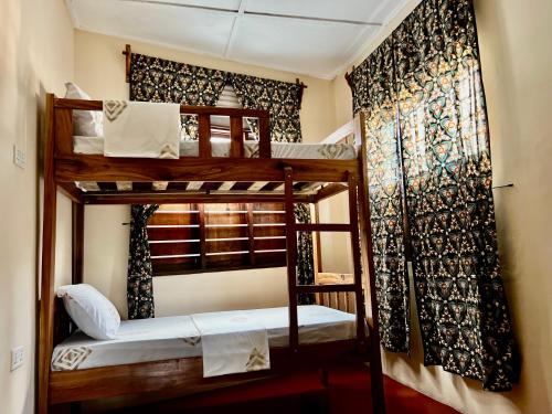 two bunk beds in a room with a curtain at Serene Abodes in Zanzibar City