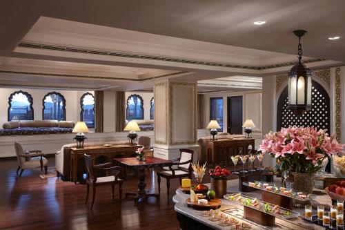 a lobby of a hotel with tables and chairs at Fairmont Jaipur in Jaipur