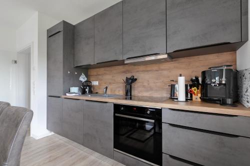 a kitchen with a sink and a stove top oven at Seelenwärmerstuuv in Kronprinzenkoog