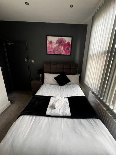 a bedroom with a white bed with a black and white blanket at Town Centre En Suite Room 1 in Barnstaple