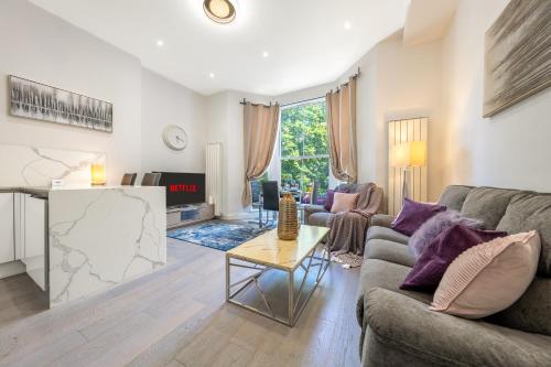 a living room with a couch and a table at Maida Vale - Carlton Vale Apartments in London