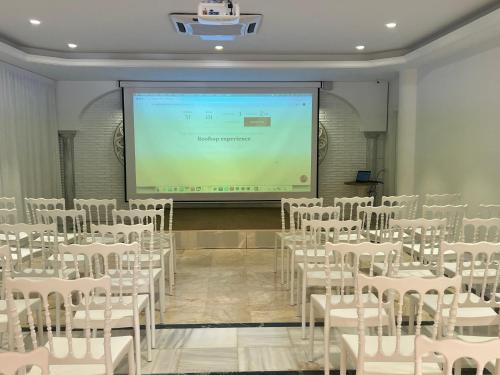 a room with white chairs and a projection screen at Hotel Villa Flamenca in Nerja
