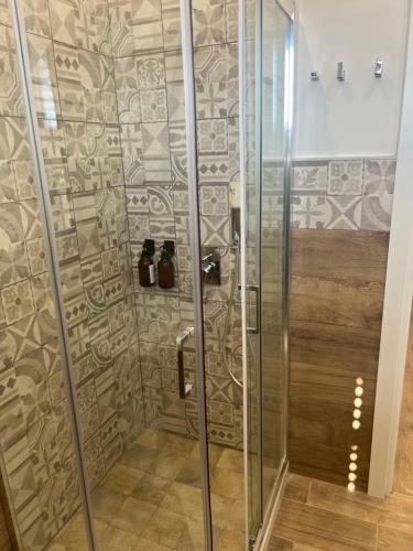 une douche avec une porte en verre dans une salle de bain dans l'établissement Scilia casa vacanza, à Palerme