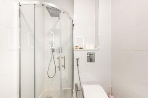 a white bathroom with a shower and a sink at Maida Vale - Carlton Vale Apartments in London