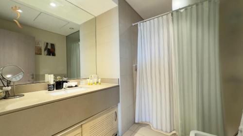 a bathroom with a shower curtain and a sink at Rodeo Retreat - Chic 1BR Apartment on Yas Island, 12 Min to Grand Prix in Abu Dhabi