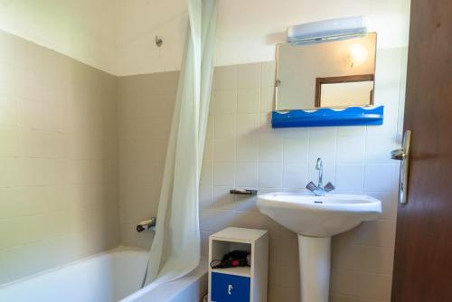 une salle de bain avec un lavabo, un miroir et une baignoire dans l'établissement Gîte Gîte 