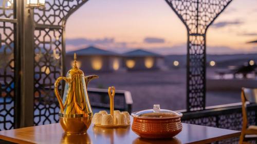 a table with a gold pitcher and a bowl on it at Stars Gate Camp in Al Wāşil