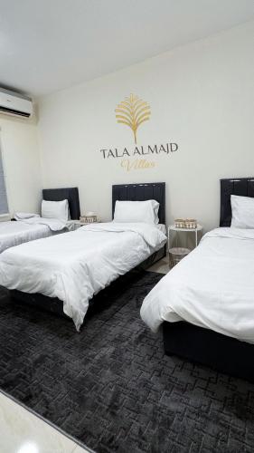 two beds in a room with a sign on the wall at Elegant 3 bedrooms Villa Relax & Enjoy family only in Jeddah