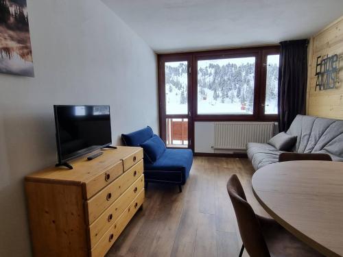 un salon avec une télévision, un canapé et une table dans l'établissement Studio rénové cosy à Plagne Centre avec balcon, skis aux pieds - FR-1-351-176, à La Plagne Tarentaise