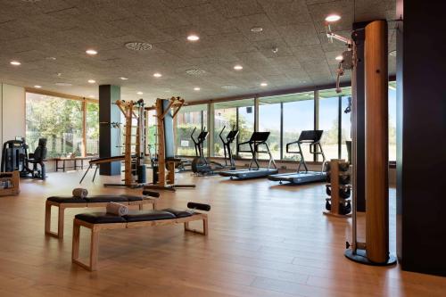 a gym with a bunch of treadms and pilates equipment at Hotel Peralada Wine Spa & Golf in Peralada