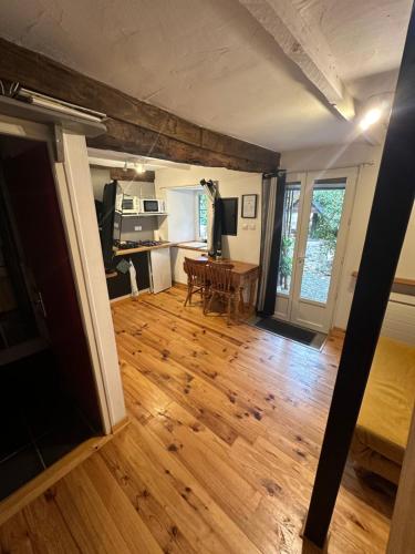 Il comprend un salon doté de parquet et d'une table. dans l'établissement Cottage including secret garden, à La Trinité-Porhoët