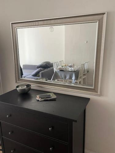 un miroir au-dessus d'une commode avec une table dans l'établissement Dans le coeur de la cité, à Marseille