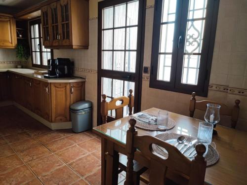 a kitchen with a wooden table and a table and chairs at villa verónica in Arriate
