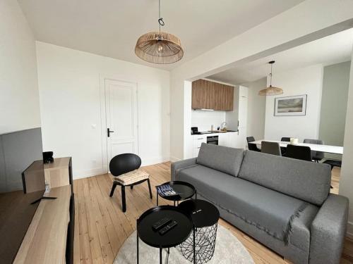 un salon avec un canapé et une table dans l'établissement L'Oasis Vue Mer- MALO LES BAINS, à Dunkerque