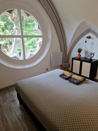 une chambre avec un grand lit avec une grande fenêtre dans l'établissement La Chapelle du Coteau, à Nomexy