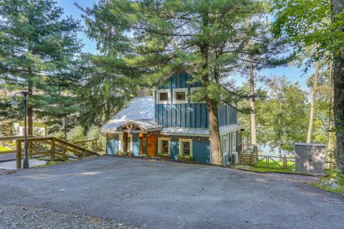 a house with a tree in front of a driveway at Lakefront Gem with Hot Tub and Boat Dock in Greentown in Greentown
