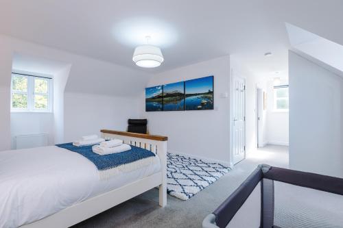a white bedroom with a bed and a painting on the wall at Grange House in Chester