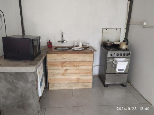 a small kitchen with a stove and a microwave at Península Dorada in San Gregorio de Polanco