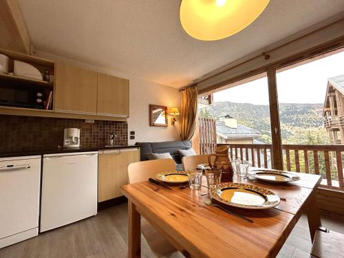Il comprend une cuisine et une salle à manger avec une table en bois. dans l'établissement Appartement Montagne 4 pers à Méribel, Proche Pistes et Commerces, Animaux Acceptés - FR-1-180-99, à Méribel