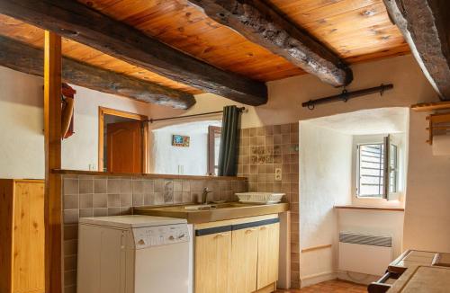 La cuisine est équipée d'un évier et d'un lave-vaisselle blanc. dans l'établissement La maison de malaury, à Laval-du-Tarn