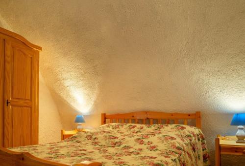 - une chambre avec un lit et 2 tables avec des lampes dans l'établissement La maison de malaury, à Laval-du-Tarn