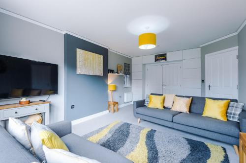 a living room with a blue couch and a tv at Grange House in Chester