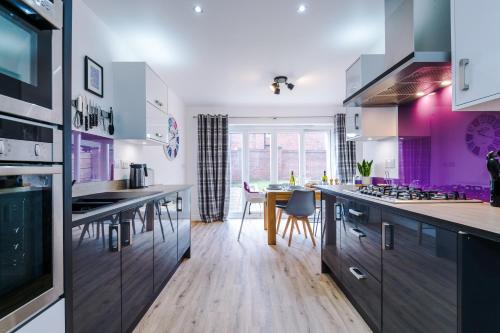 a kitchen with white and purple cabinets and a table at Grange House in Chester