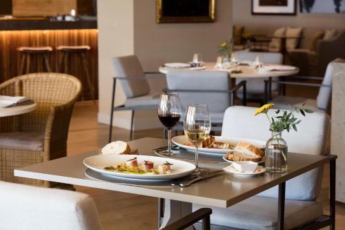 a table with two plates of food and glasses of wine at Hotel Peralada Wine Spa & Golf in Peralada